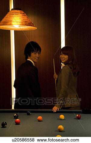 Stock Photo - Business colleagues standing next to a pool table. Fotosearch