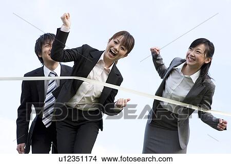 Picture - Businessman and businesswomen crossing finish line. Fotosearch
