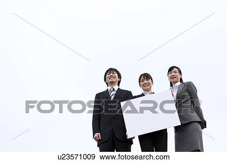 Businessman and businesswomen holding message board View Large Photo Image Stock Photo - Businessman and businesswomen holding message board. Fotosearch