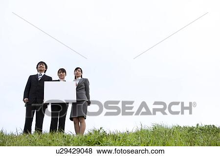 Businessman and businesswomen holding message board View Large Photo Image Stock Photo - Businessman and businesswomen holding message board. Fotosearch