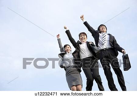 Stock Image - Businessman and businesswomen punching air. Fotosearch