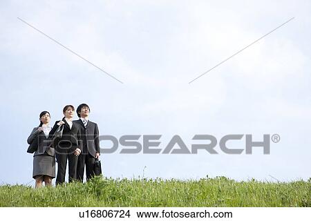 Businessman and businesswomen standing on grass View Large Photo Image Picture - Businessman and businesswomen standing on grass. Fotosearch