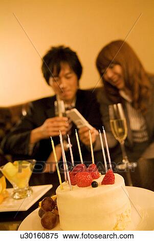 Stock Photography - Businessman and woman celebrating and looking at a cellphone. Fotosearch