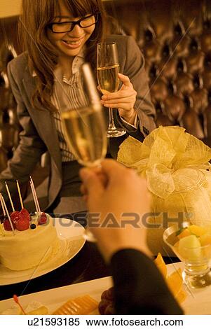 Stock Photography - Businessman and woman celebrating with champagne. Fotosearch
