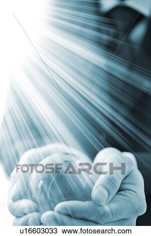 Businessman holding a globe with light shining onto it View Large Photo Image Stock Image - Businessman holding a globe with light shining onto it. Fotosearch