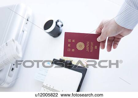 Businessman holding a passport View Large Photo Image Stock Image - Businessman holding a passport. Fotosearch