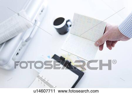 Stock Image - Businessman holding a passport. Fotosearch