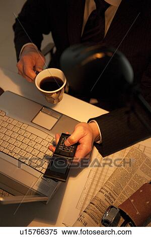 Businessman holding mobile phone and coffee View Large Photo Image Stock Photography - Businessman holding mobile phone and coffee. Fotosearch