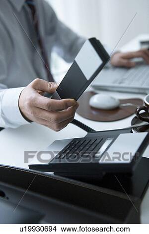 Picture - Businessman holding telephone receiver. Fotosearch