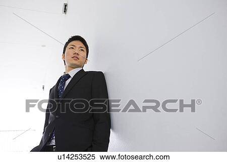 Businessman leaning on a wall View Large Photo Image Stock Photography - Businessman leaning on a wall. Fotosearch