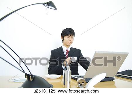 Stock Photography - Businessman looking at a notebook PC. Fotosearch