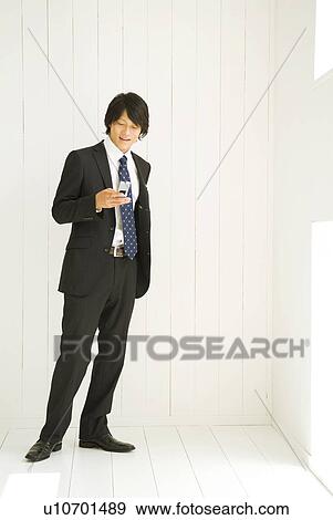 Businessman looking at mobile phone View Large Photo Image Stock Photo - Businessman looking at mobile phone. Fotosearch