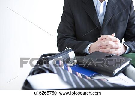 Stock Image - Businessman packing a suitcase. Fotosearch
