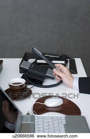 Businessman picking up telephone receiver View Large Photo Image Stock Photograph - Businessman picking up telephone receiver. Fotosearch