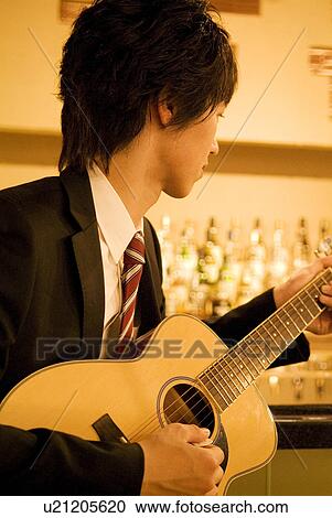 Businessman playing guitar at the bar View Large Photo Image Stock Image - Businessman playing guitar at the bar. Fotosearch