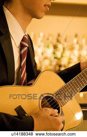 Businessman playing guitar at the bar View Large Photo Image Stock Photo - Businessman playing guitar at the bar. Fotosearch