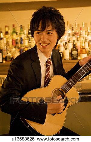Businessman playing guitar at the bar View Large Photo Image Stock Photograph - Businessman playing guitar at the bar. Fotosearch