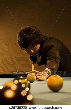 Stock Image - Businessman playing pool. Fotosearch