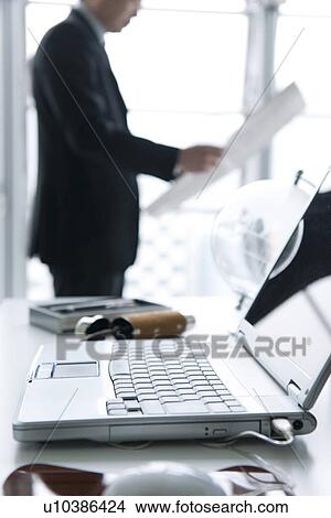 Businessman reading newspaper in office View Large Photo Image Picture - Businessman reading newspaper in office. Fotosearch