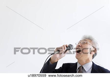 Stock Photo - Businessman singing into microphone. Fotosearch