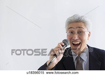 Stock Photography - Businessman singing into microphone. Fotosearch