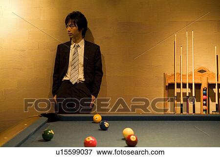 Businessman standing behind a pool table View Large Photo Image Stock Photo - Businessman standing behind a pool table. Fotosearch