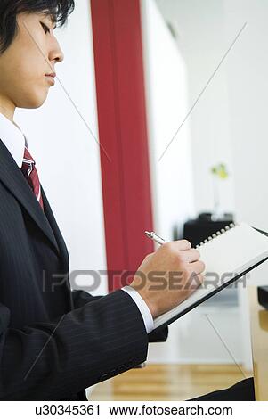 Stock Image - Businessman taking a memo on a note pad. Fotosearch