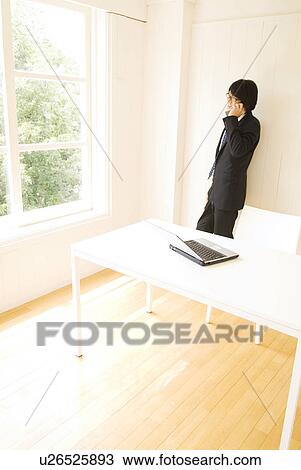 Stock Image - Businessman talking on mobile phone. Fotosearch