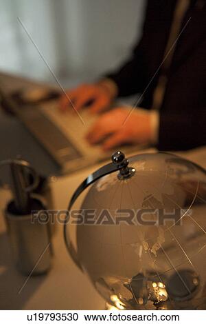 Stock Image - Businessman working at desk in office. Fotosearch