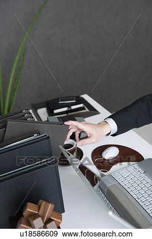 Businessman working at desk in office View Large Photo Image Stock Photo - Businessman working at desk in office. Fotosearch