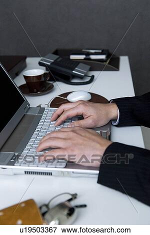 Businessman working at desk in office View Large Photo Image Stock Photo - Businessman working at desk in office. Fotosearch