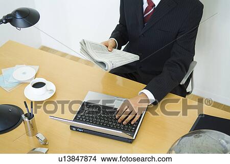 Businessman working at his desk View Large Photo Image Picture - Businessman working at his desk. Fotosearch