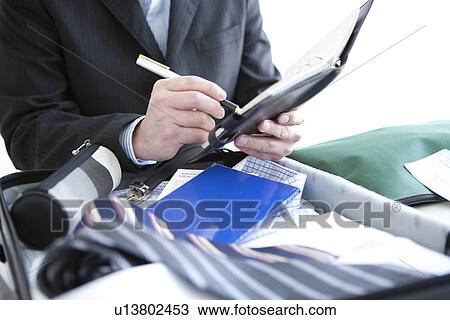 Stock Image - Businessman writing in a diary. Fotosearch