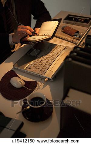 Stock Image - Businessman writing in personal organizer. Fotosearch