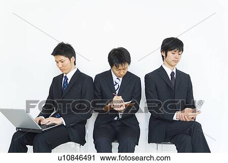 Stock Image - Businessmen with laptop, mobile phone and personal organizer. Fotosearch