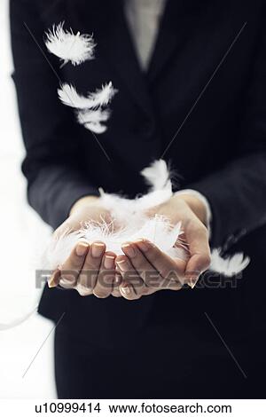 Picture - Businesswoman catching feathers. Fotosearch
