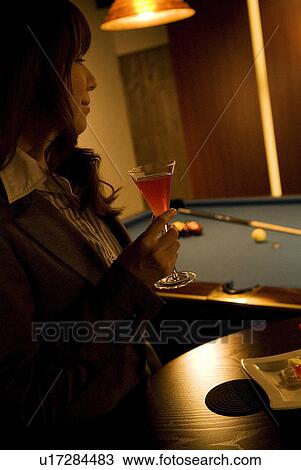 Businesswoman drinking a cocktail at a bar View Large Photo Image Stock Image - Businesswoman drinking a cocktail at a bar. Fotosearch