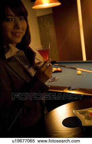 Businesswoman drinking a cocktail at a bar View Large Photo Image Stock Photography - Businesswoman drinking a cocktail at a bar. Fotosearch
