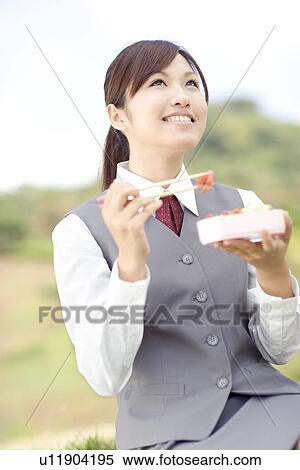 Stock Photography - Businesswoman eating lunch outside. Fotosearch