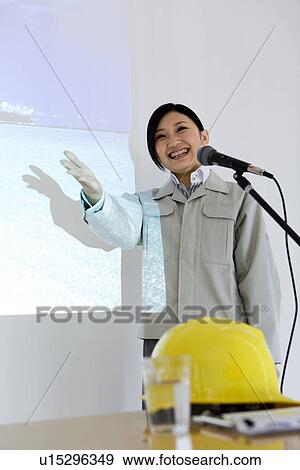 Stock Photo - Businesswoman giving presentation with projector screen. Fotosearch