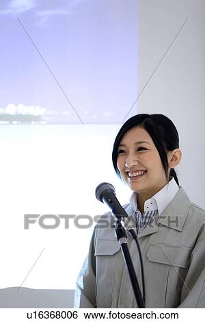 Stock Photograph - Businesswoman giving presentation with projector screen. Fotosearch