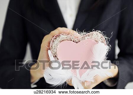 Businesswoman holding a heart shaped gift box View Large Photo Image Picture - Businesswoman holding a heart shaped gift box. Fotosearch