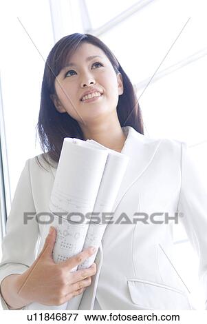 Stock Photo - Businesswoman holding blueprints. Fotosearch