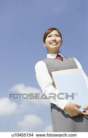 Picture - Businesswoman holding documents. Fotosearch