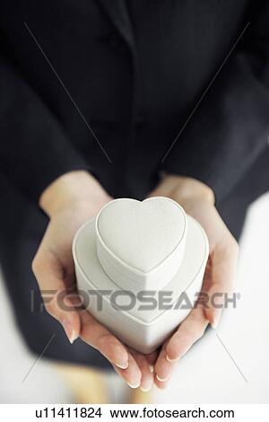 Picture - Businesswoman holding heart shaped gift boxes. Fotosearch