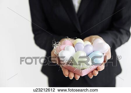 Stock Image - Businesswoman holding heart shaped soaps. Fotosearch