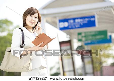 Businesswoman holding personal organizer at bus stop View Large Photo Image Stock Image - Businesswoman holding personal organizer at bus stop. Fotosearch