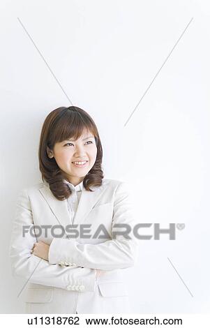 Businesswoman leaning against wall with arms crossed View Large Photo Image Stock Image - Businesswoman leaning against wall with arms crossed. Fotosearch