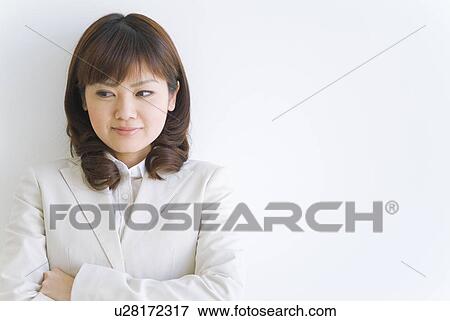 Businesswoman leaning against wall with arms crossed View Large Photo Image Stock Photo - Businesswoman leaning against wall with arms crossed. Fotosearch