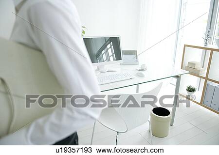 Stock Image - Businesswoman leaving home office. Fotosearch